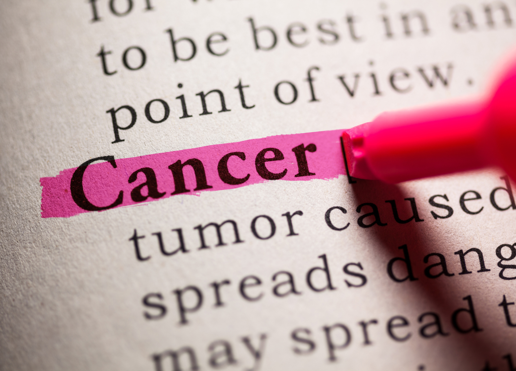 Dictionary page with the word 'Cancer' highlighted in pink marker.