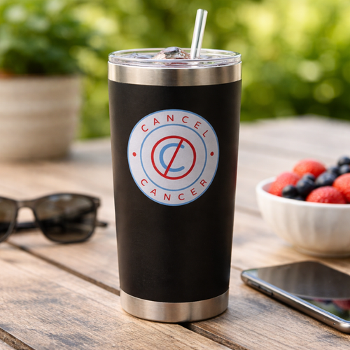 Black tumbler with 'Cancel Cancer' logo on a wooden table with berries and sunglasses.