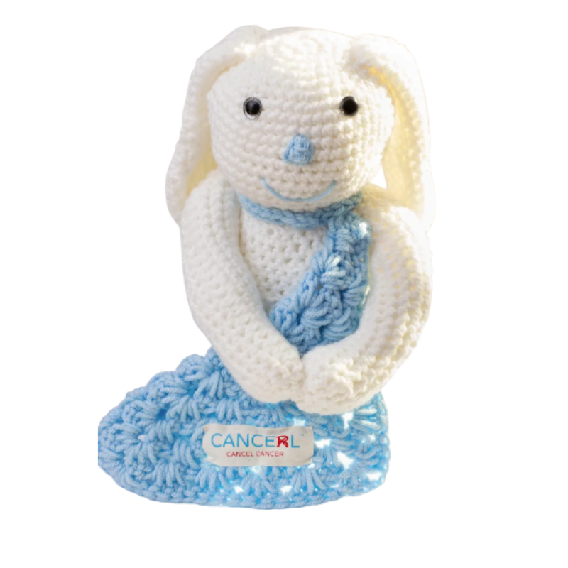 Crocheted bunny with a blue scarf on a white background, featuring the Cancel Cancer logo.